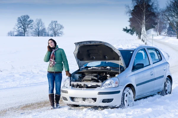 woman stood by car on the phone, car has the hood up and has broken down